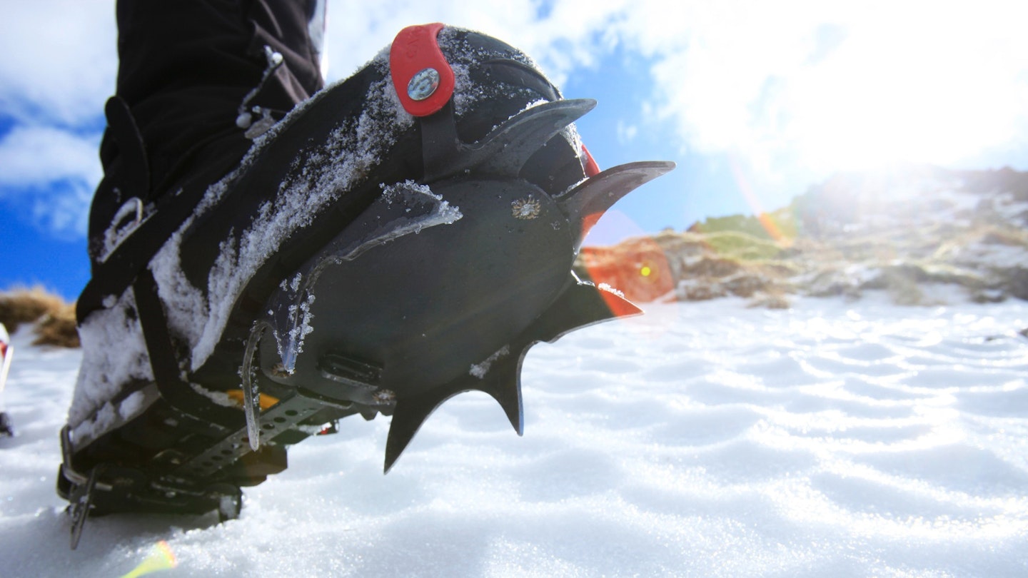 A hiking boot fitted with a crampon